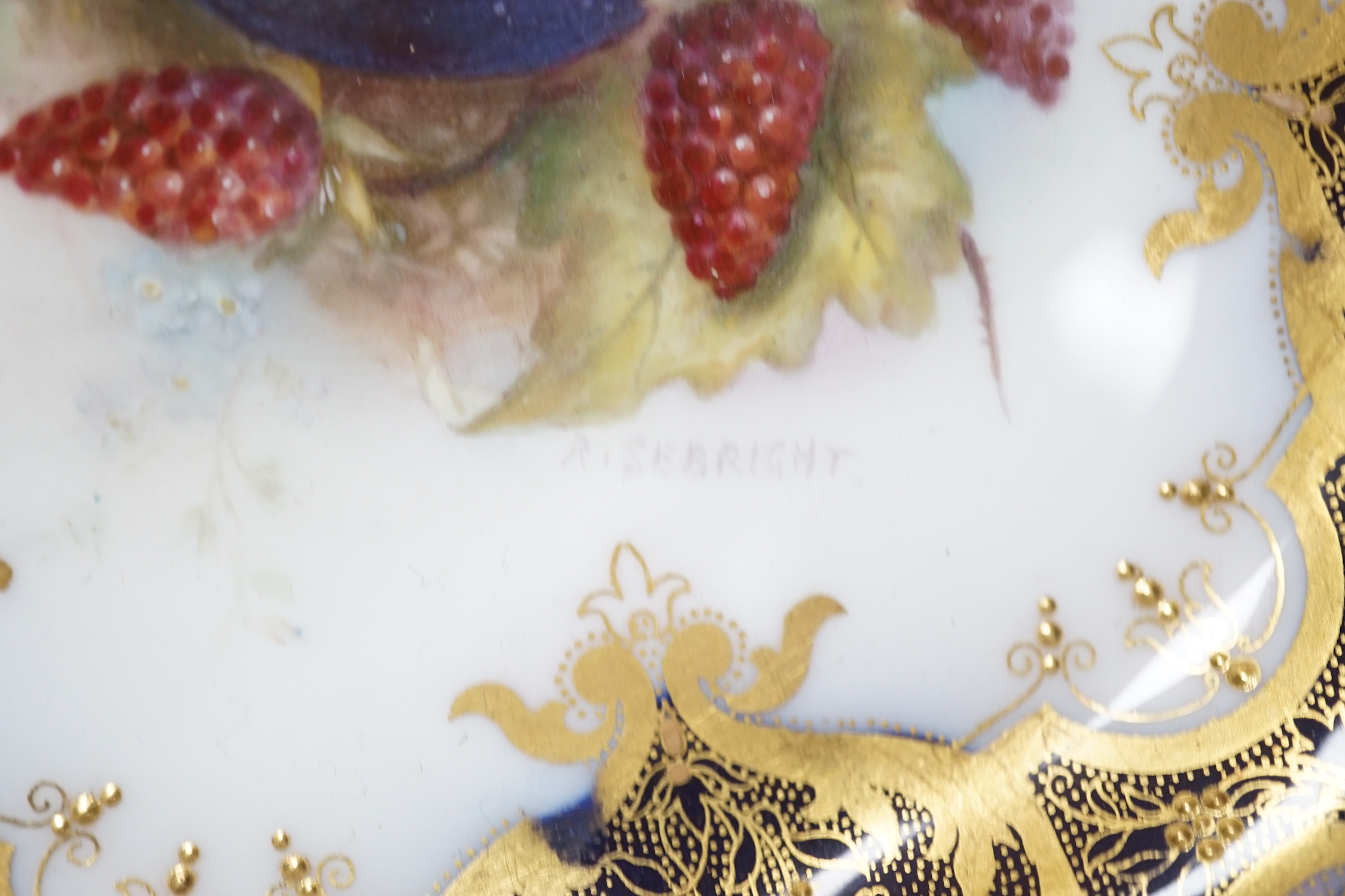 A Royal Worcester plate painted with fruit and berries by R. Sebright, signed, under a blue and gilt ground, date mark 1918